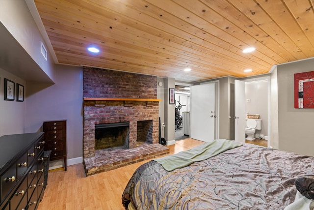 bedroom with wood ceiling, ensuite bath, a fireplace, and light hardwood / wood-style floors