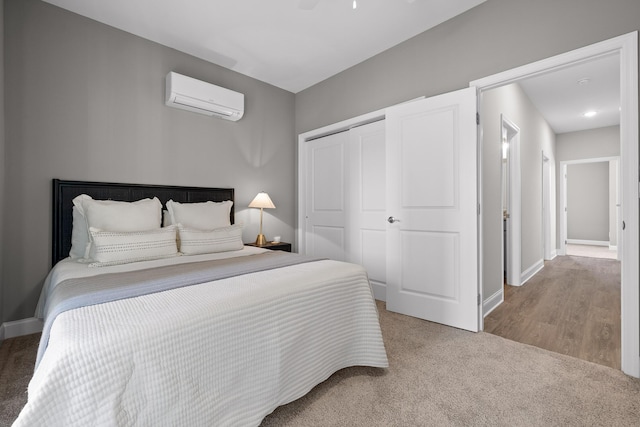 carpeted bedroom featuring a closet, a wall unit AC, and baseboards