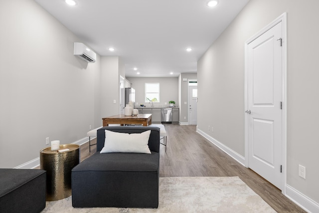 living area with recessed lighting, an AC wall unit, baseboards, and wood finished floors