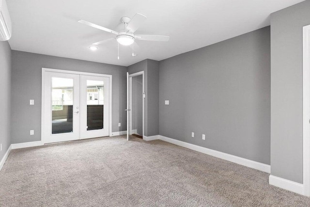 carpeted spare room featuring ceiling fan and french doors