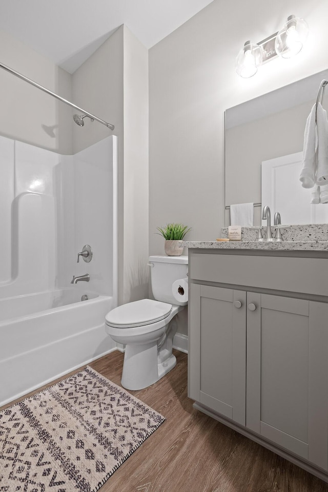 bathroom featuring shower / bathing tub combination, vanity, toilet, and wood finished floors