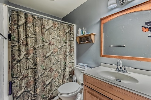 bathroom with curtained shower, vanity, and toilet