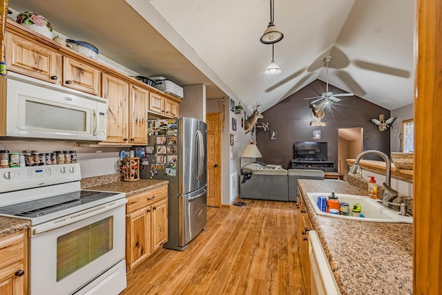 kitchen featuring lofted ceiling, hanging light fixtures, light wood-style floors, a sink, and white appliances