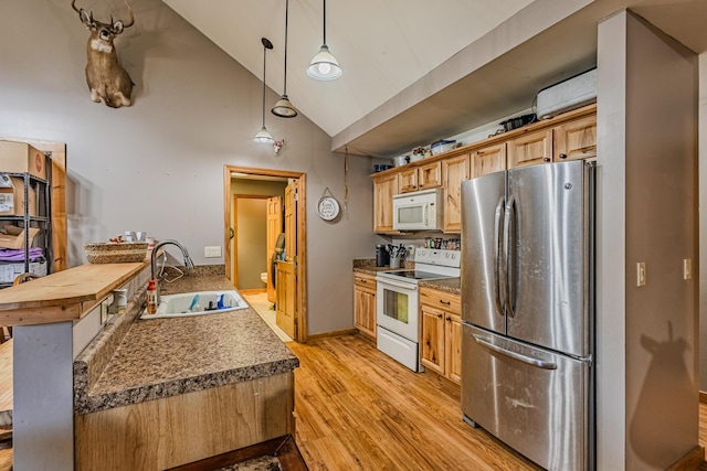 kitchen with high vaulted ceiling, white appliances, a sink, hanging light fixtures, and light wood-type flooring