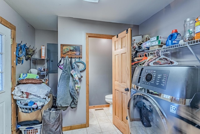 laundry area with baseboards, laundry area, washer / dryer, and tile patterned floors