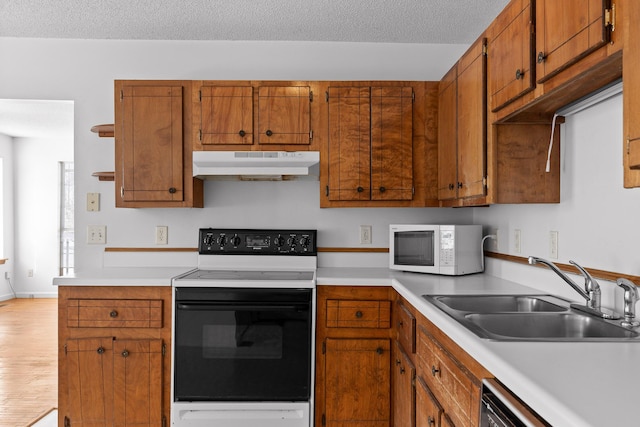 kitchen with dishwashing machine, electric range, sink, and a textured ceiling