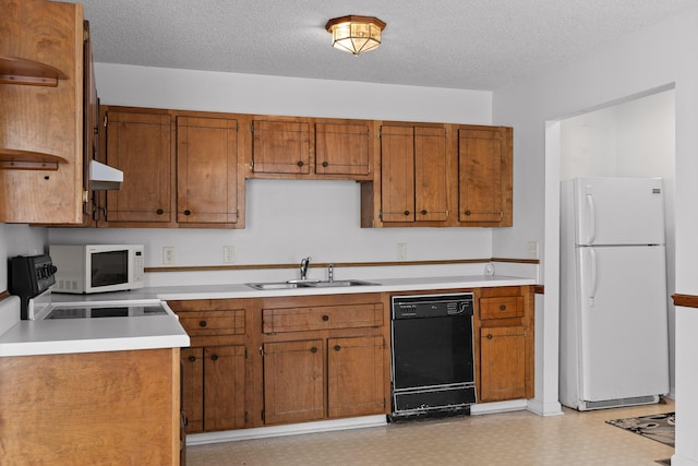 kitchen featuring sink, white appliances, and a textured ceiling