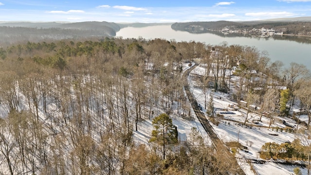 snowy aerial view featuring a water and mountain view