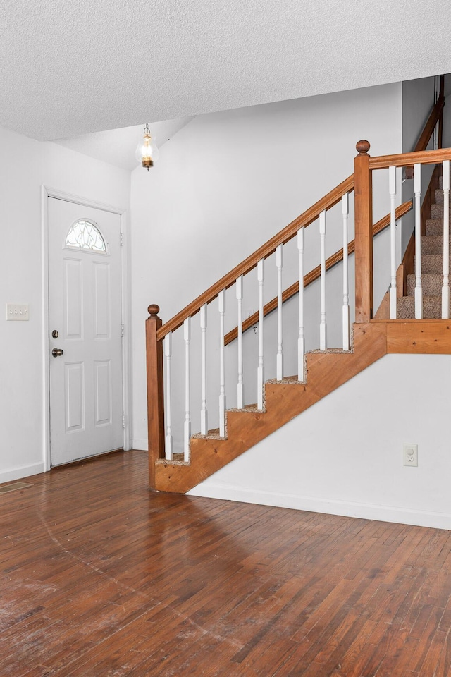 entryway featuring a textured ceiling and dark hardwood / wood-style flooring