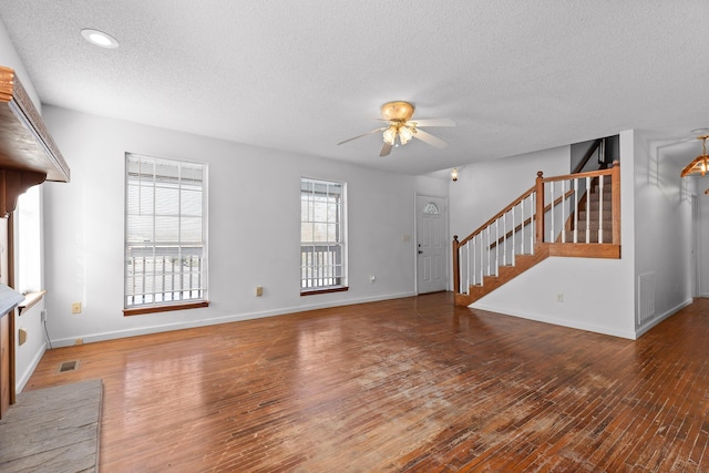 unfurnished living room with ceiling fan, a textured ceiling, and dark hardwood / wood-style floors