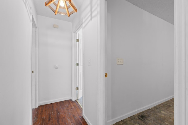 corridor with dark wood-type flooring and a textured ceiling