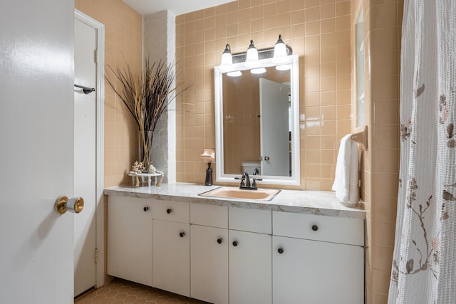 bathroom with tile walls, vanity, and tile patterned floors