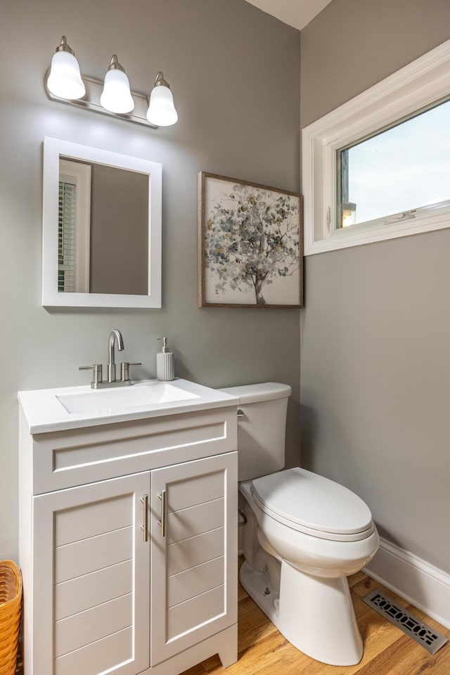 bathroom with hardwood / wood-style flooring, vanity, and toilet