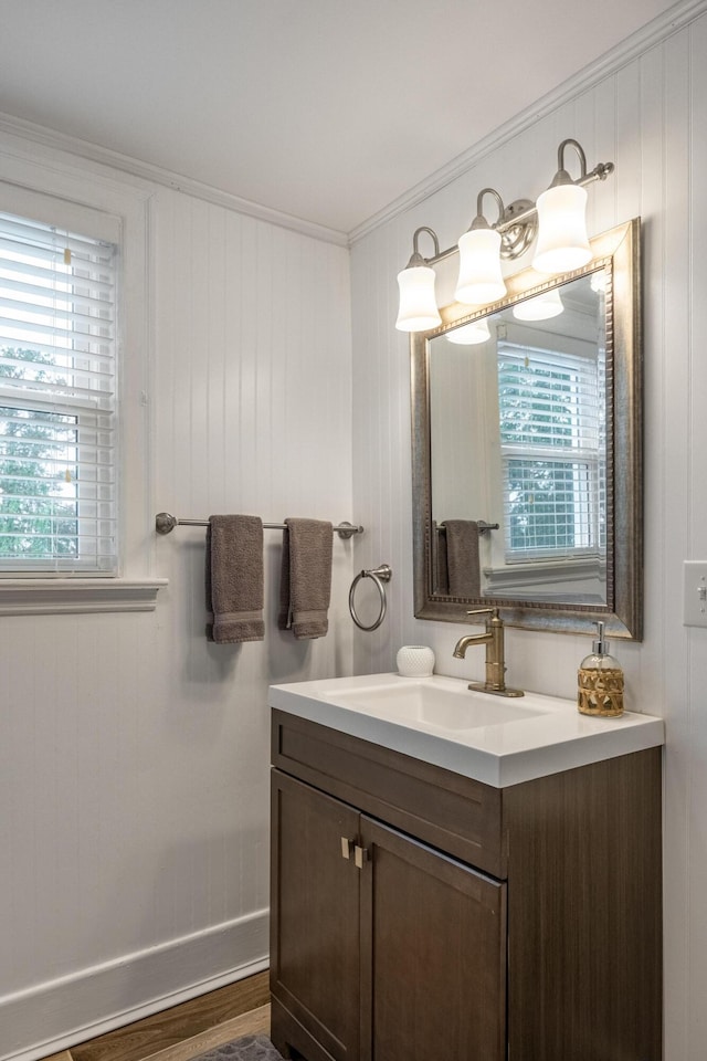 bathroom featuring hardwood / wood-style flooring, vanity, a wealth of natural light, and crown molding