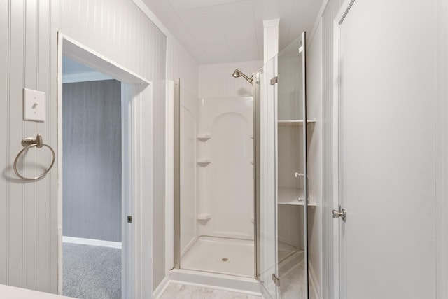 bathroom featuring walk in shower and wooden walls