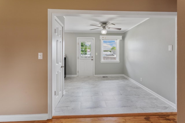 interior space with ceiling fan and crown molding