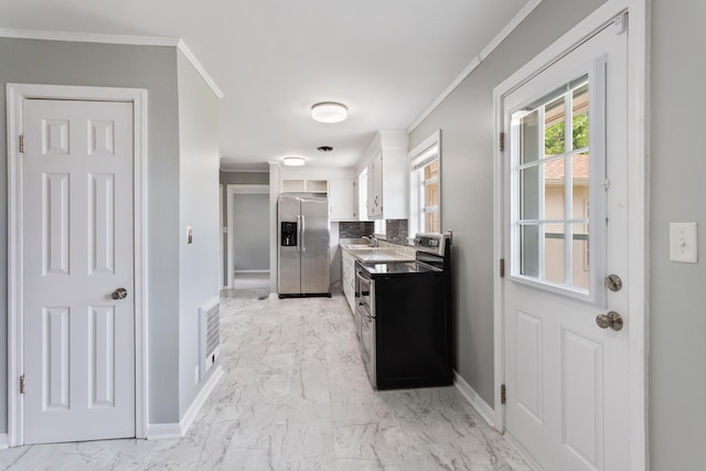 kitchen with sink, white cabinets, ornamental molding, and appliances with stainless steel finishes