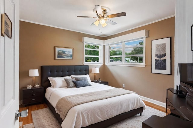 bedroom featuring light hardwood / wood-style flooring, ceiling fan, and crown molding