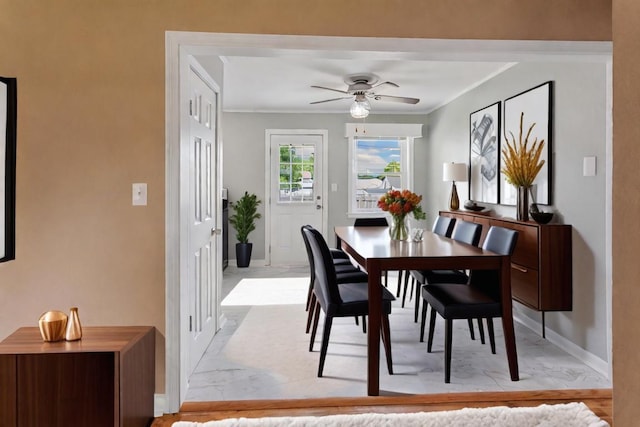 dining area with ceiling fan and crown molding