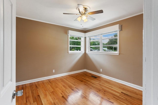 empty room featuring ceiling fan, ornamental molding, and hardwood / wood-style flooring