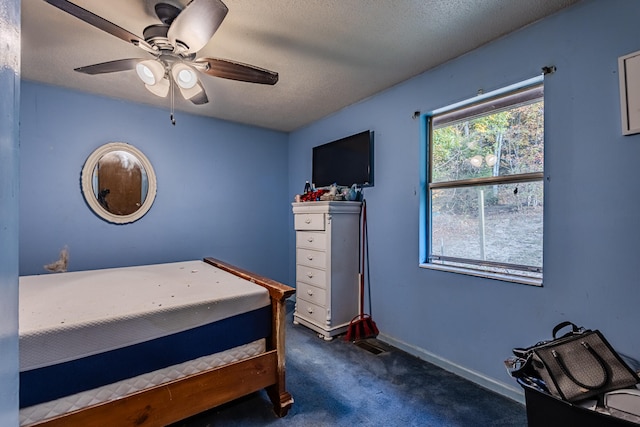 carpeted bedroom with a textured ceiling and ceiling fan