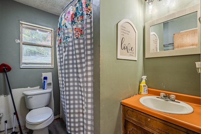 bathroom with a shower with curtain, vanity, a textured ceiling, and toilet