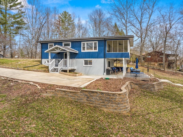 back of property featuring a patio area and a lawn