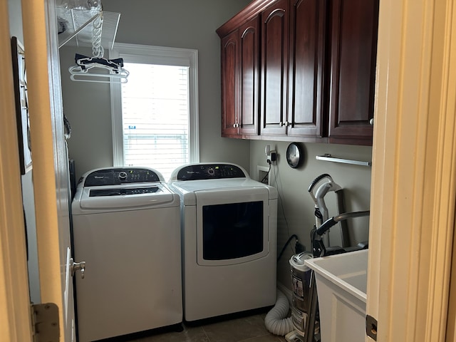 washroom featuring cabinets, separate washer and dryer, and dark tile patterned floors