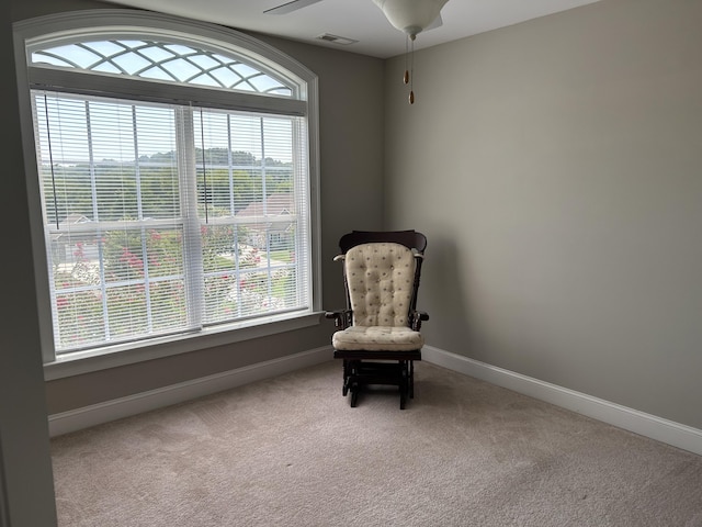 living area with light colored carpet, a wealth of natural light, and ceiling fan