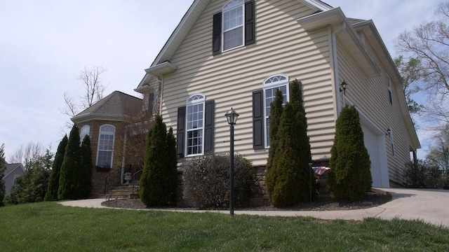 view of side of property with a yard and a garage