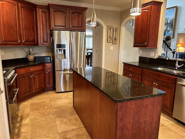 kitchen featuring appliances with stainless steel finishes, ornamental molding, sink, decorative light fixtures, and dark stone countertops