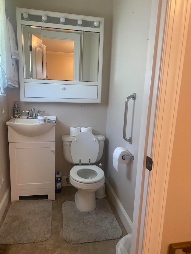 bathroom featuring tile patterned flooring, vanity, and toilet