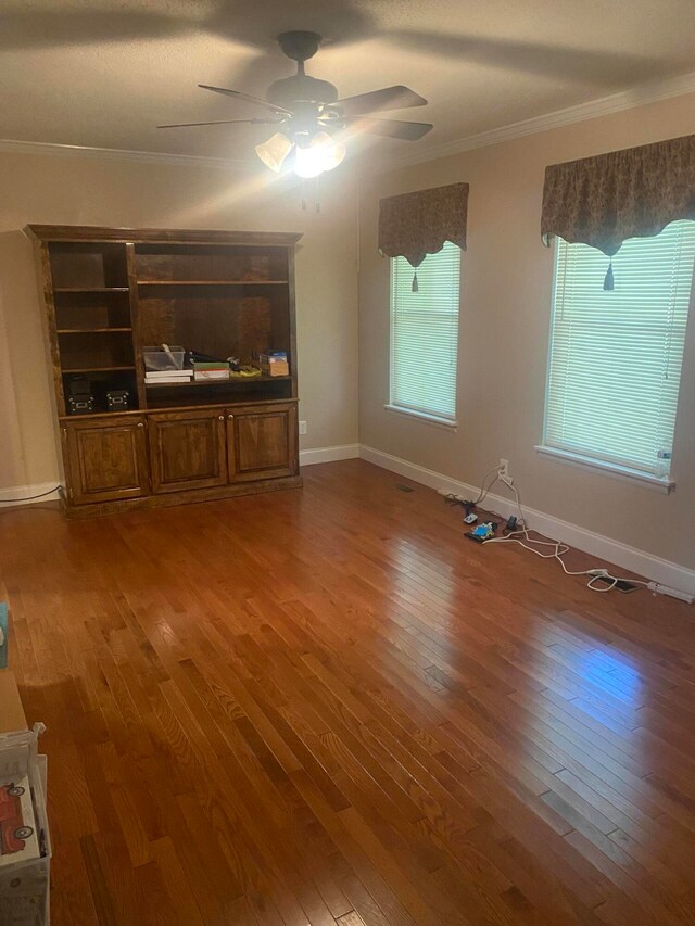 unfurnished living room featuring ceiling fan, hardwood / wood-style floors, and ornamental molding