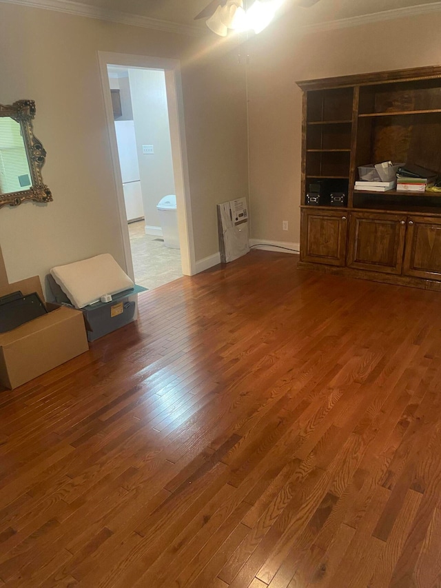 unfurnished living room with ceiling fan, ornamental molding, and dark wood-type flooring