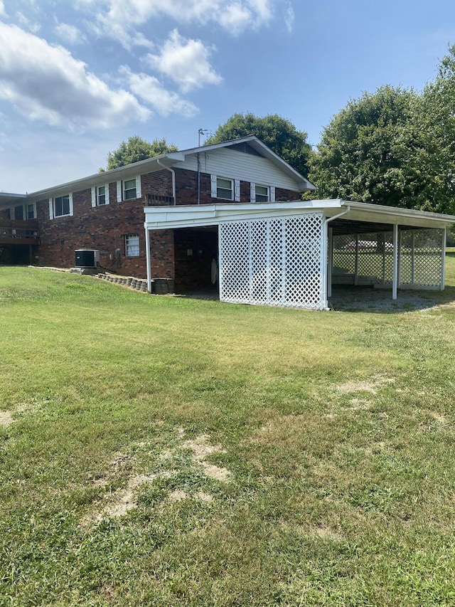 exterior space featuring a yard, central AC unit, and a carport