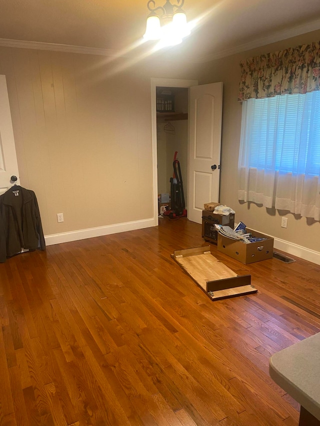 empty room with wood-type flooring and ornamental molding