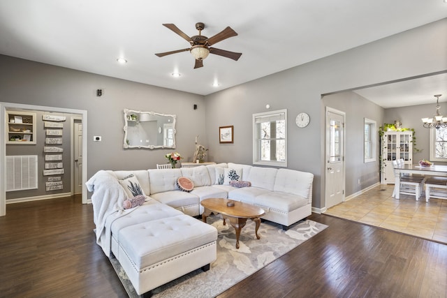 living room featuring hardwood / wood-style flooring and ceiling fan with notable chandelier