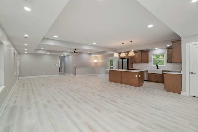 826 Long Mill Rd, Athens, TN 37303 - kitchen with appliances with stainless steel finishes, a kitchen island, open floor plan, light wood finished floors, and tasteful backsplash