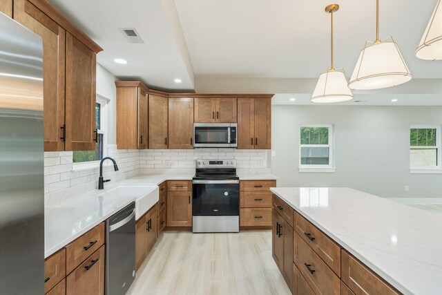826 Long Mill Rd, Athens, TN 37303 - kitchen featuring appliances with stainless steel finishes, a sink, backsplash, light wood-style flooring, and brown cabinets