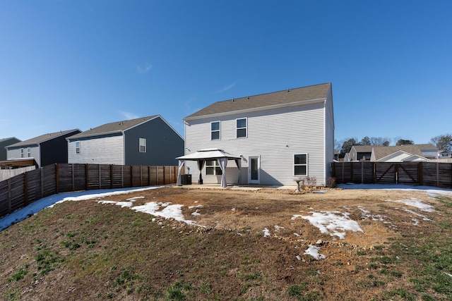 rear view of property featuring a lawn and a gazebo