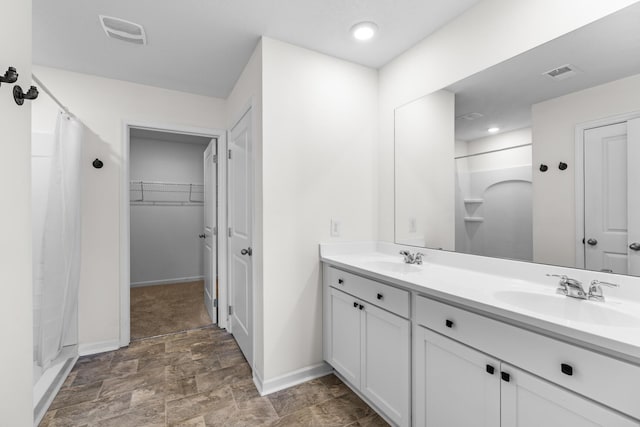 bathroom featuring walk in shower and vanity