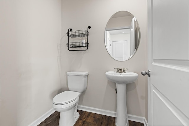 bathroom featuring toilet, sink, and hardwood / wood-style flooring