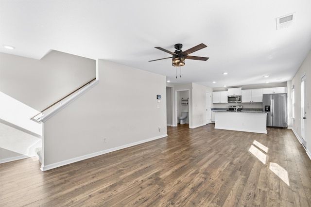 unfurnished living room with ceiling fan and dark hardwood / wood-style flooring