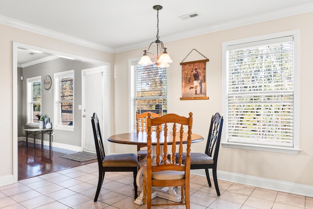 dining space featuring light tile patterned flooring, a chandelier, and ornamental molding