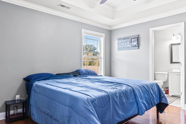 bedroom featuring ensuite bath, ceiling fan, hardwood / wood-style floors, and ornamental molding