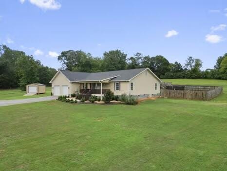 ranch-style house with an outdoor structure, covered porch, and a front yard