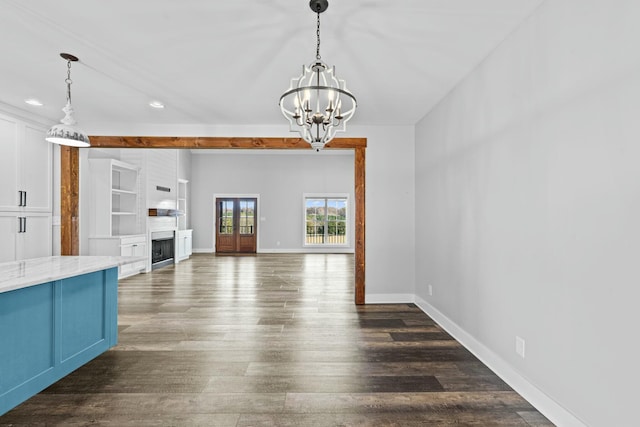 unfurnished living room featuring dark wood-type flooring and an inviting chandelier