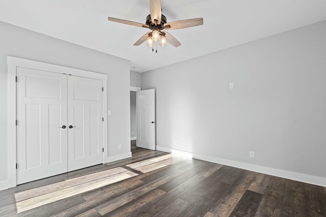 unfurnished bedroom with a closet, ceiling fan, and dark wood-type flooring