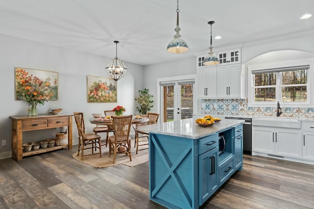 kitchen with blue cabinetry, white cabinetry, sink, hanging light fixtures, and dark hardwood / wood-style floors