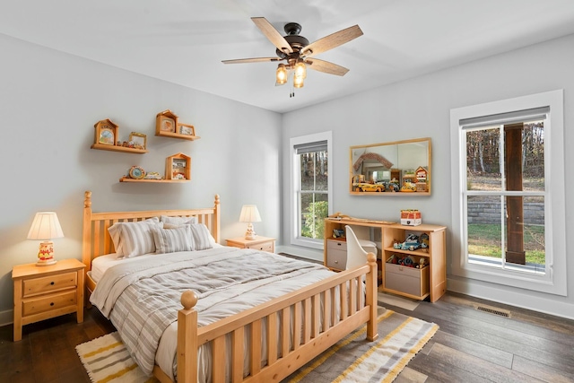 bedroom with multiple windows, ceiling fan, and dark wood-type flooring